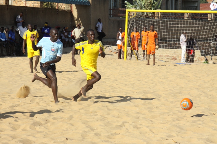 Nkumba Select's Muganga Douglas (Right in yellow) and Mutesa I Royal University player run after the ball.