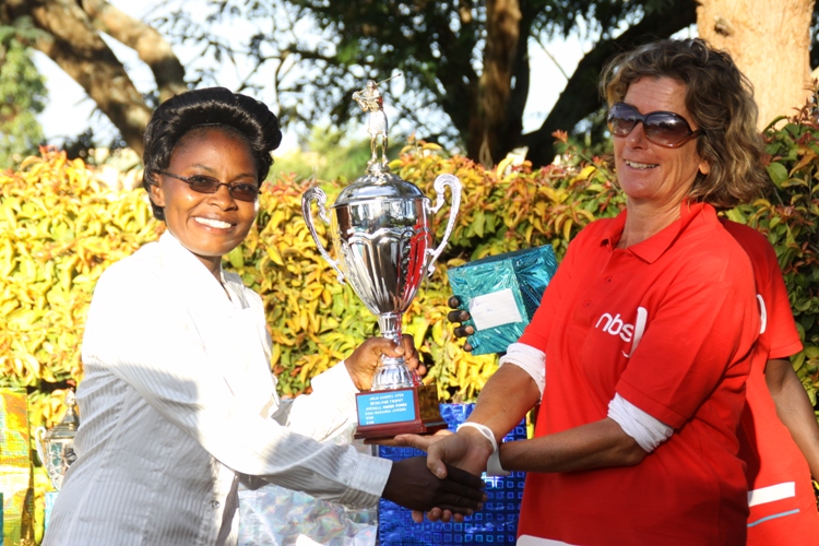 Jinja's lady member Catherine Buettner hands over a trophy to Lillian Kabui.