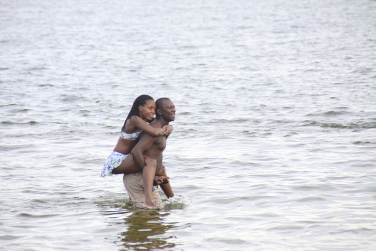 Man carries babe in the water.