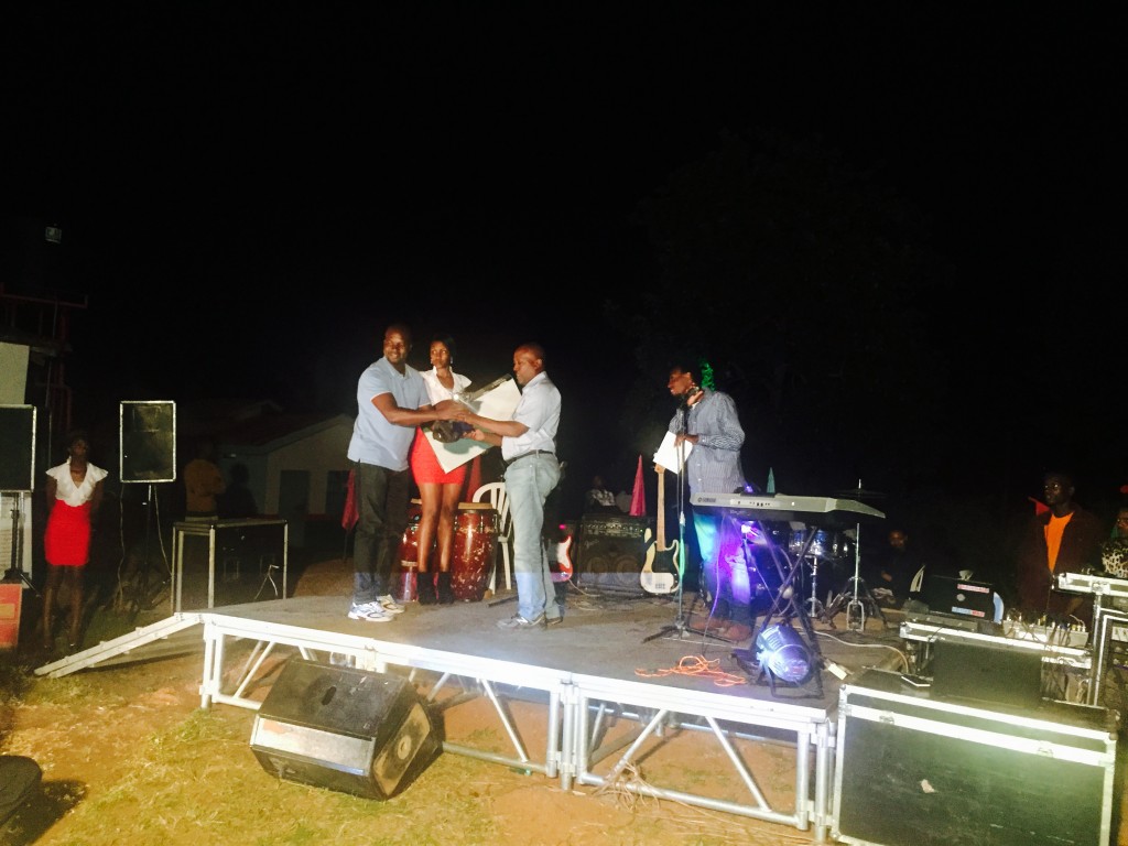Ali receiving his microwave in Mbarara after the open.