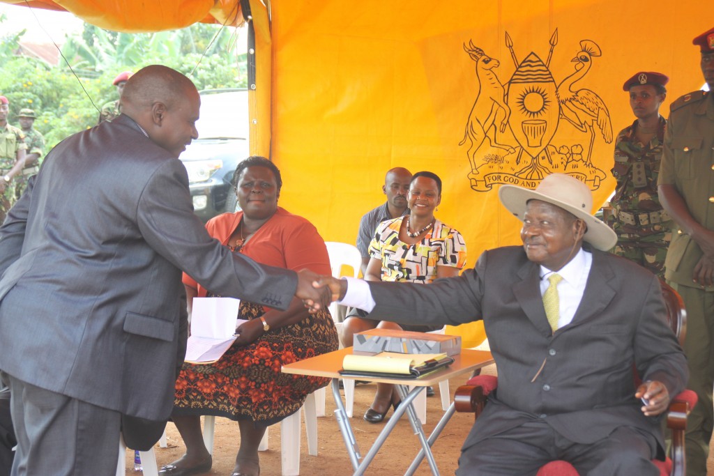 Hon. Muhammad Kawuma(L) Handshaking President Yoweri Museveni's hands at a past function In Entebbe.
