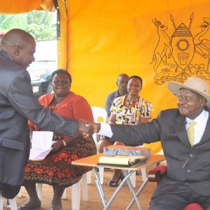 Hon. Muhammad Kawuma(L) Handshaking President Yoweri Museveni's hands at a past function  In Entebbe.