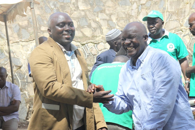 Stanley Namayirira and Anthony Seguja shake hands after lasy year's heated party primaries. Stanley beat Seguja 12-11 votes. They are in bitter split.