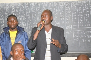Entebbe NRM EC Boss Paul Wasike announcing the results at the Changsha Primary school.