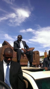Besigye seated on top of vehicle. He received a sofar chair from city traders. 