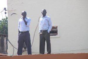Men observe DP Campaign drive on top of a building.