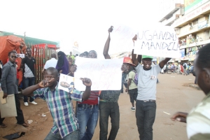 Supporters flash placards in down town Kampala.
