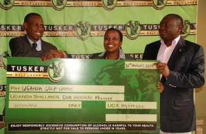 UBL Marketing Director Grace Nshemeire hands a cheque to Uganda Golf Union Vice president Kiryowa Kiwanuka. Looking on is the Secretary Johnson Omolo.