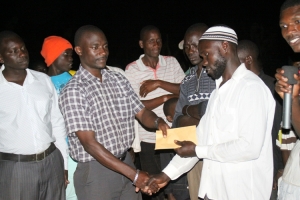 Entebbe Airport NRM Vice Chairman Kasaga Emmanuel hands over a cheque to the boat cruise winners.