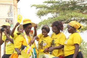 Rose Tumusiime's supporters surround her like bees.