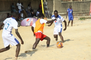 Muteesa I Royal players (in white) mark a Real Galacticals player. They lost 3-1 to Real Galacticals.