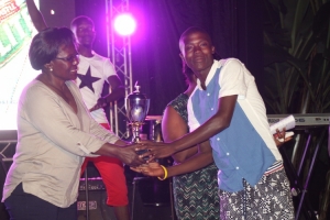 Winner of the Subsidiary men's category Mutebi Deco receives his trophy from Monica Ntege. 