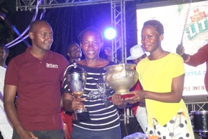 Irene Nakalembe (C) receives the EBB Ladies Open trophy from Castle Lite Brand Manager Julian Sentamu. Left is Britam's Edgar Muzahura.