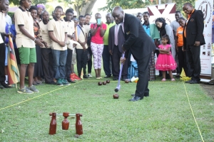 Muramagi tries out the sport of Wood ball at the Kisubi Beach.