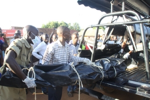 Police cops loading the deceased's body on a police patrol car.