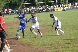 Kampala University defender Frank Sebuliba(in white) marks Nkumba's Ramathan Kibirango. Nkumba lost 1-0.