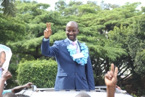 Ibrahim Semujju Nganda waving FDC Party sign.