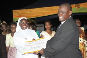 Andrew Nadiope Gabula hands over certificate of excellence to Elizabeth Alitubeera.