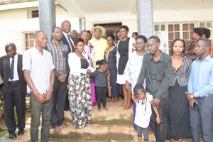 President Museveni poses for a group photo with Hon. Tumusiime's family on Wednesday at her residence. He consoled and comforted her.