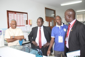 From left: Fagil Mandy, Dr. Sam Okware and Dr. Amandua Jacinto listen to Kamushaga Zeph (in blue T-shirt) during a tour of the UVRI Laboratories.