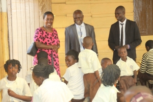 Hon. Tumusiime and pastor Mayanja Stanley greet pupils during a school tour.