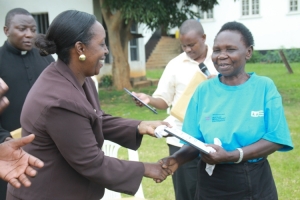 Hon. Tumusiime hands over certificates to members.