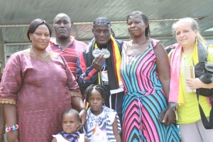 titus-tugume-displays-his-medals-he-is-flanked-by-his-mum-in-marron-dress-and-coach-corinne-matovu