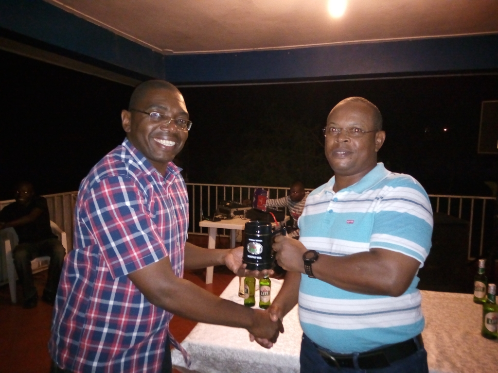 John Muchiri receives his Mug From Moses Ssebugwawo, the Entebbe Club Treasurer.