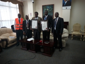 CAA Airports Director Eng. John Kagoro(3rd from right) with other CAA officials during the unveiling of the ISO Certificates.