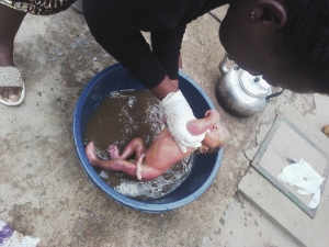 Good Samaritan cleaning up the baby.