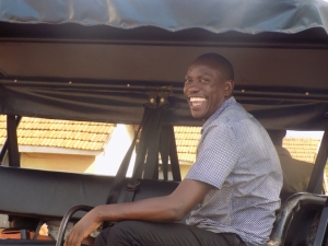 Charles Kyagaba smiling on a police truck