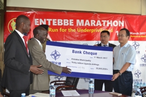 Entebbe Municipality Mayor Vicent Kayanja Depaul Receiving A Shs 30M Dummy Cheque From The Chinese Construction Company Boss To Facilitate The Entebbe Marathon 2017(By PEACOCK KAWEESA)