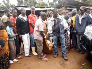 Residents carry the body of the deceased on a Police Pick up truck.