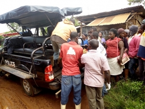 Residents load the body of the deceased on a Police Pick up truck. The body was taken to Mulago Hospital for a postmortem.