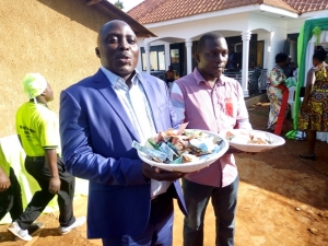 Division B Chairman Stanley Namayirira and his Kid Bro Andrew Luwemba holding baskets of cash that was collected during the Kasiki on Thursday.