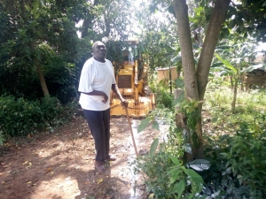Mr. Moska Okaka looks at his Ovacodo tree for the last time before it was destroyed.