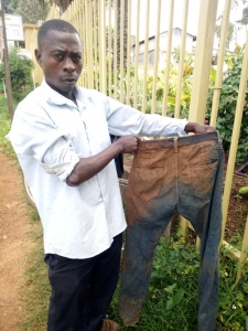 Ssali Musa who was tortured by SFC Soldiers in Entebbe displays his dirty trousers after he was forced to roll in the mud. He reported an assault case at the Entebbe Police Station.