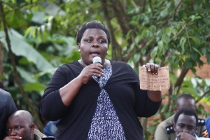 RDC Nalongo Rose Kirabira displays an anonymous letter during the community meeting in Kitala that was sent to DPC Godfrey Ninsiima.
