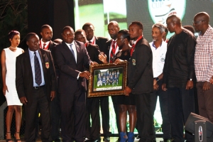 Team Uganda Captain Mwanja Becca receives a Team photo portrait from Johnson Omollo.