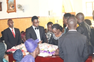 Late George Otim's children lay a wreath on his casket.