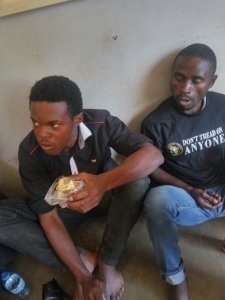 Sam Batambira (R) with another suspect at Entebbe Police Station after they were arrested.