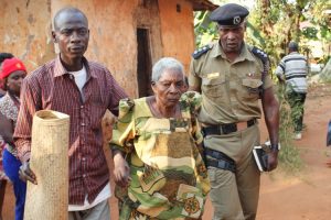 OC Station Entebbe Police Ndawula David escorts 78 year old Kasarina Kizza to a Police Pick up.