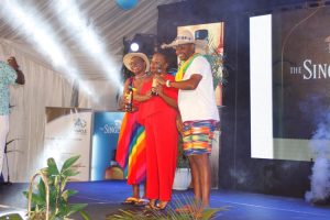 UBL Human Resource Manager (in Red) hands over bottles of Singleton Whiskey to the best dressed golfers Maxi Byenkya (left) and David Ssekitoleko.