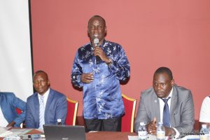Capt. Mike Mukula speaking during the UGATCA AGM at Lake Victoria Hotel on Friday. Right is the out going President Paul Kalemba and left is the incoming Ahumuza Arthur.