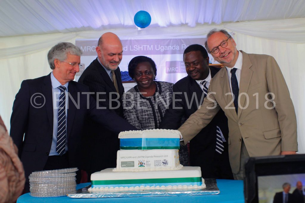 MRC/UVRI Director Prof. Pontiano Kaleebu (2nd right), Hon. Sarah Opendi and LSHTM Director Prof. Baron Peter and other guests cut a cake.