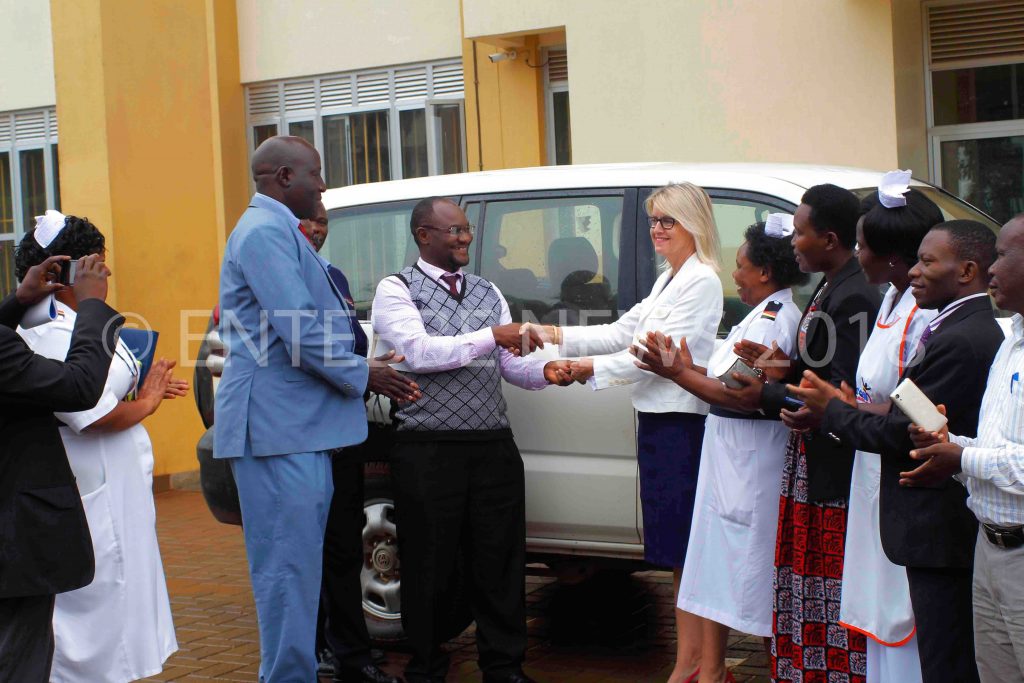 Dr. Muwanga Moses, the Entebbe General Hospital Medical Superintendent receives the vehicle from Suzanne Rupp, the MRC/UVRI&LSHTM chief operating officer on Thursday at Entebbe General Hospital. Next to Dr. Muwanga is Dan Fred Lutaaya(Entebbe Municipal Council Assistant Town Clerk)