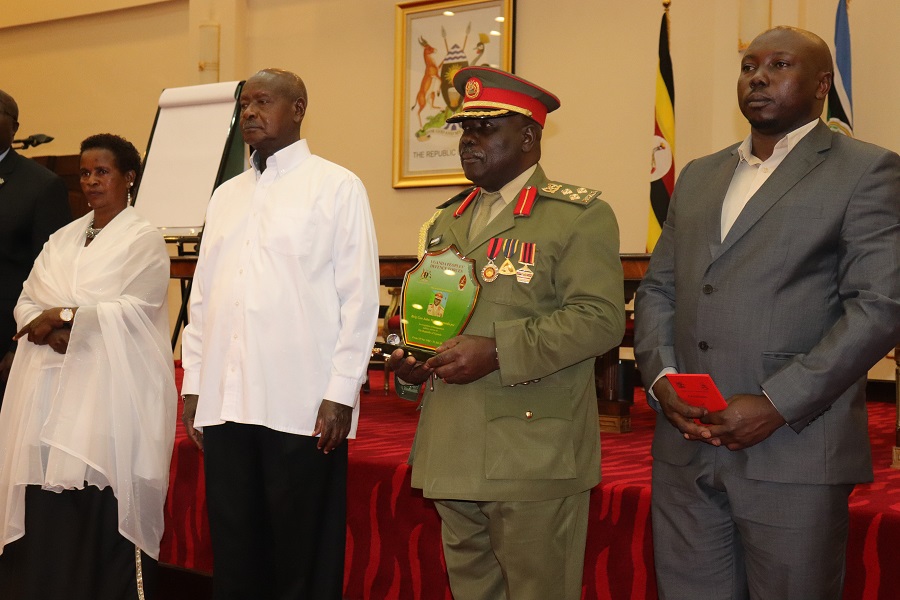 Brig.John Mary Kaganda with his family pose for a photo with President Museveni at Entebbe.