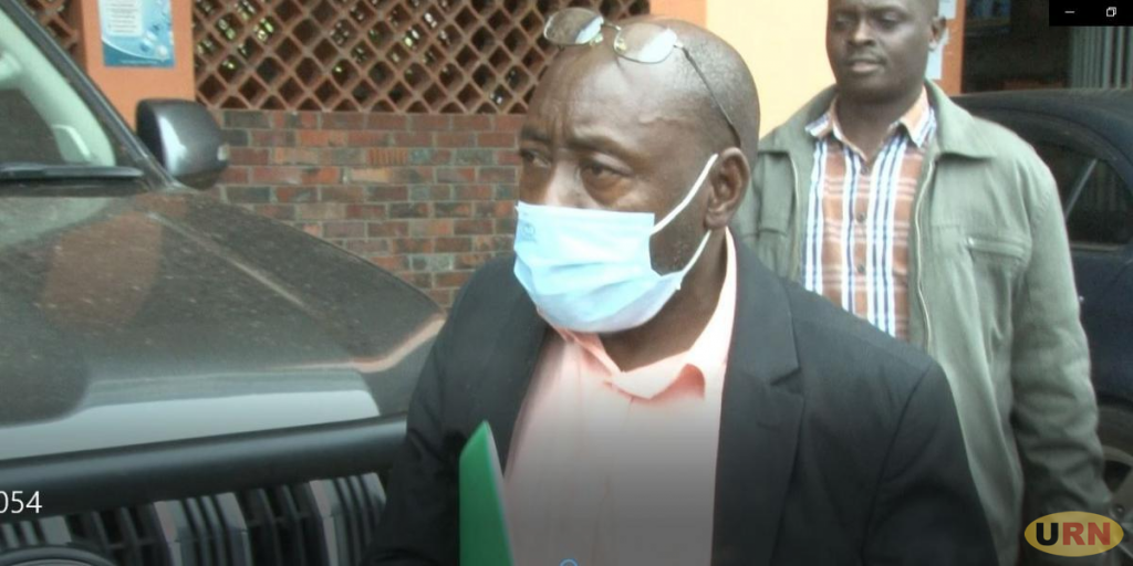 Frank Sekagiri (left) the Municipal development officer being escorted by Police officers