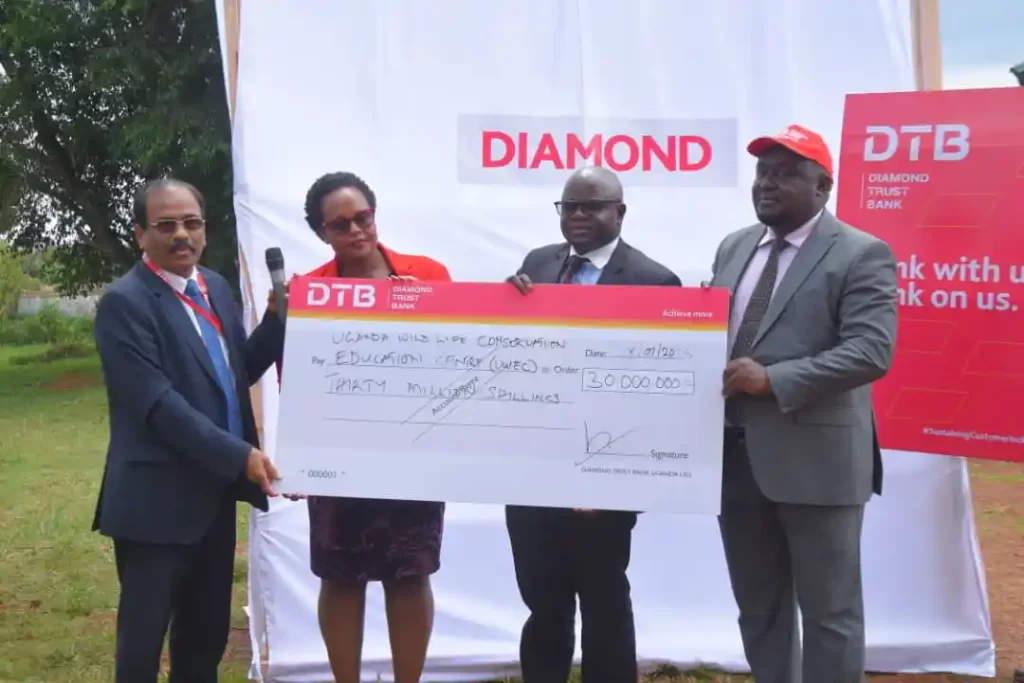 Diamond Trust Bank Managing Director Mr. Varghese Thambi (extreme left) handing over a dummy cheque to Mr. David Musingo (extreme right), the Acting Executive Director at Entebbe Zoo (PHOTO/Courtesy).