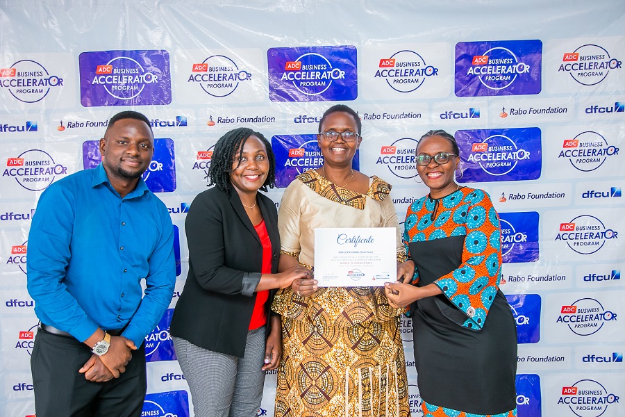 Grace Katuramu receives a certificate of completion from Ruth Asasira Head of Women in Business at dfcu bank and Josephine Mukumbya - The ED - Agribusiness Development Centre